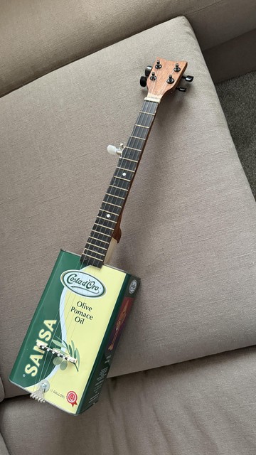 Banjo made out of a one-gallon Sansa Olive can and a cut-down child’s guitar neck.