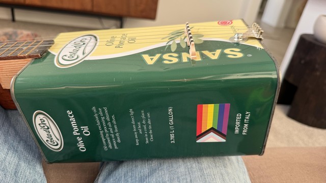 Side view of the olive oil can showing a sticker I got at Seattle Pride a couple of years ago covering the UPC code.